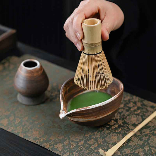 Complete matcha tea set including bowl (chawan), whisk (chasen), scoop (chashaku), and sieve, on a wooden tray